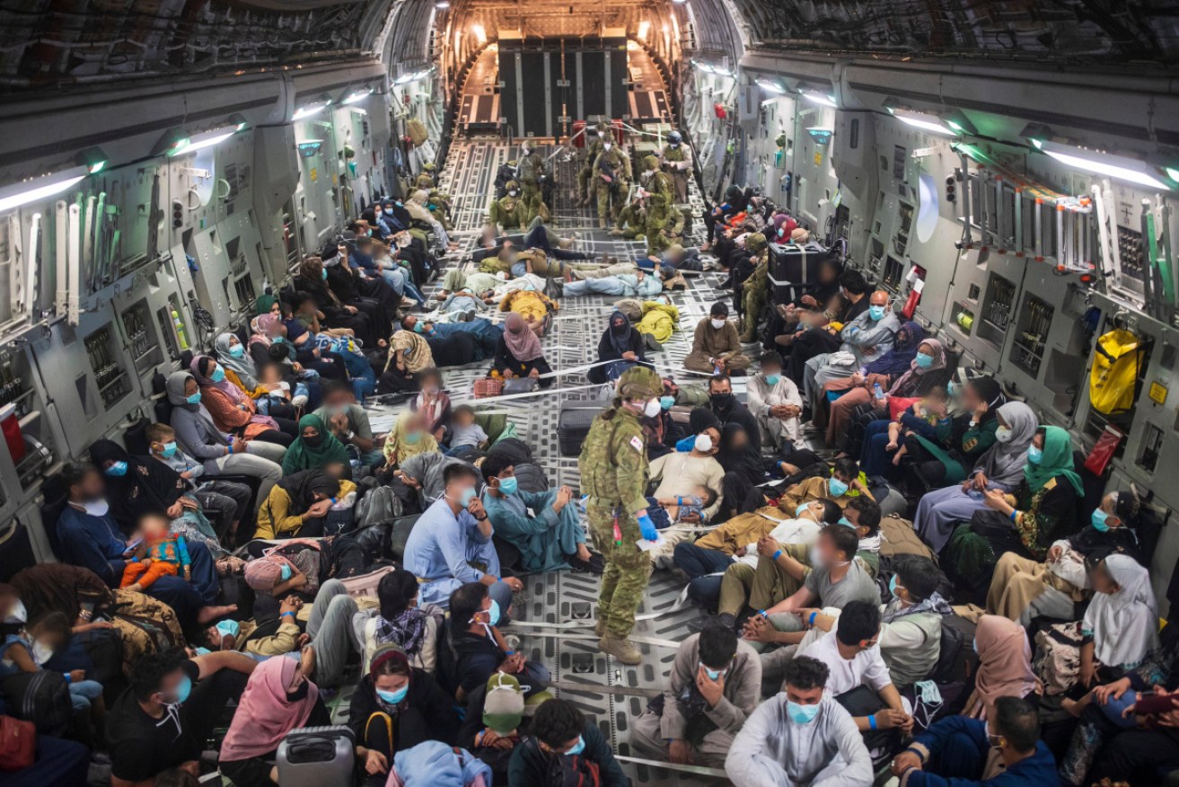 Afghan refugees aboard a flight out of Kabul on Monday. 