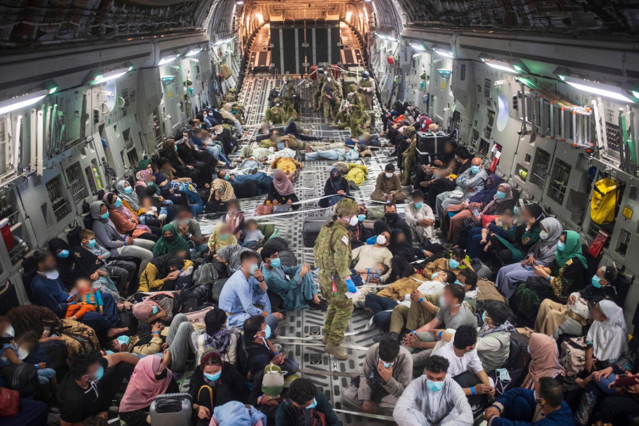Afghan refugees aboard a flight out of Kabul on Monday.