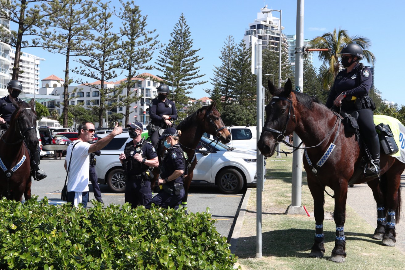 Police monitor an anti-lockdown protest at Coolangatta near the Qld-NSW border on Sunday.