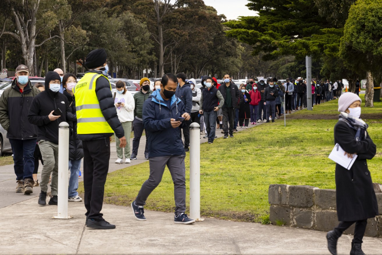 People line up for COVID vaccines at the Sandown Racecourse Vaccination Centre in Melbourne. Photo: AAP
