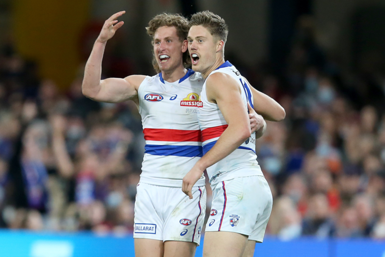 Aaron Naughton and Josh Schache of the Bulldogs celebrate a vital goal during the seesawing battle with the losing Lions.