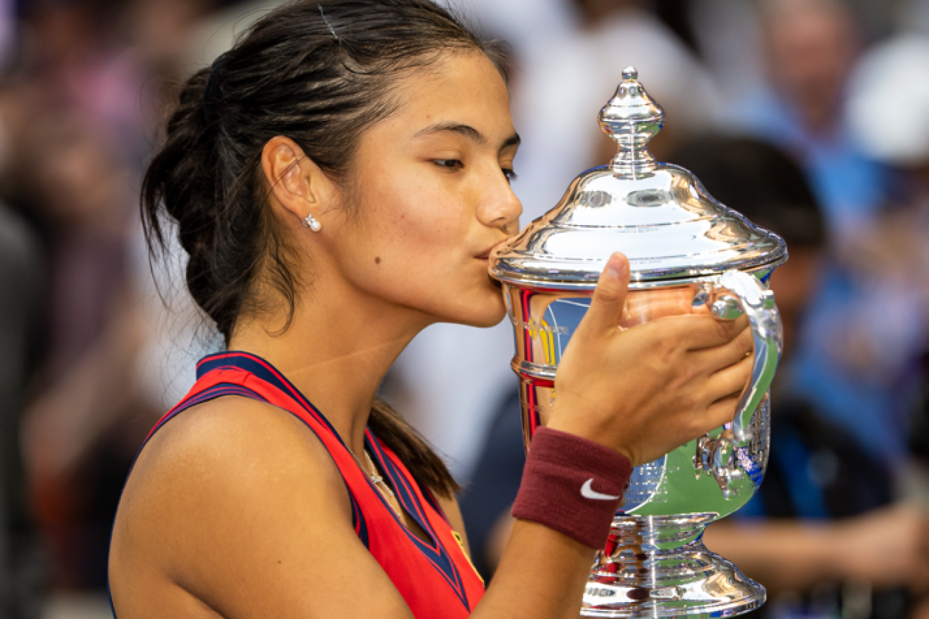 Emma Raducanu of Great Britain plants a kiss on the US Open trophy after defeating Canada's Leylah Fernandez.