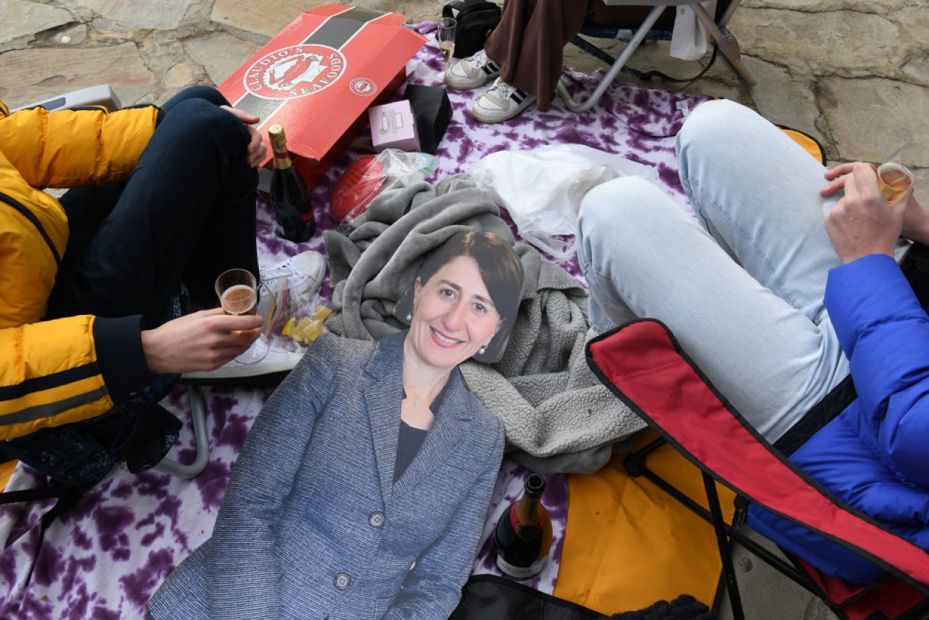 Revellers at Kirribilli enjoy a picnic with a life-sized cardboard cutout of NSW Premier Gladys Berejiklian on Monday.