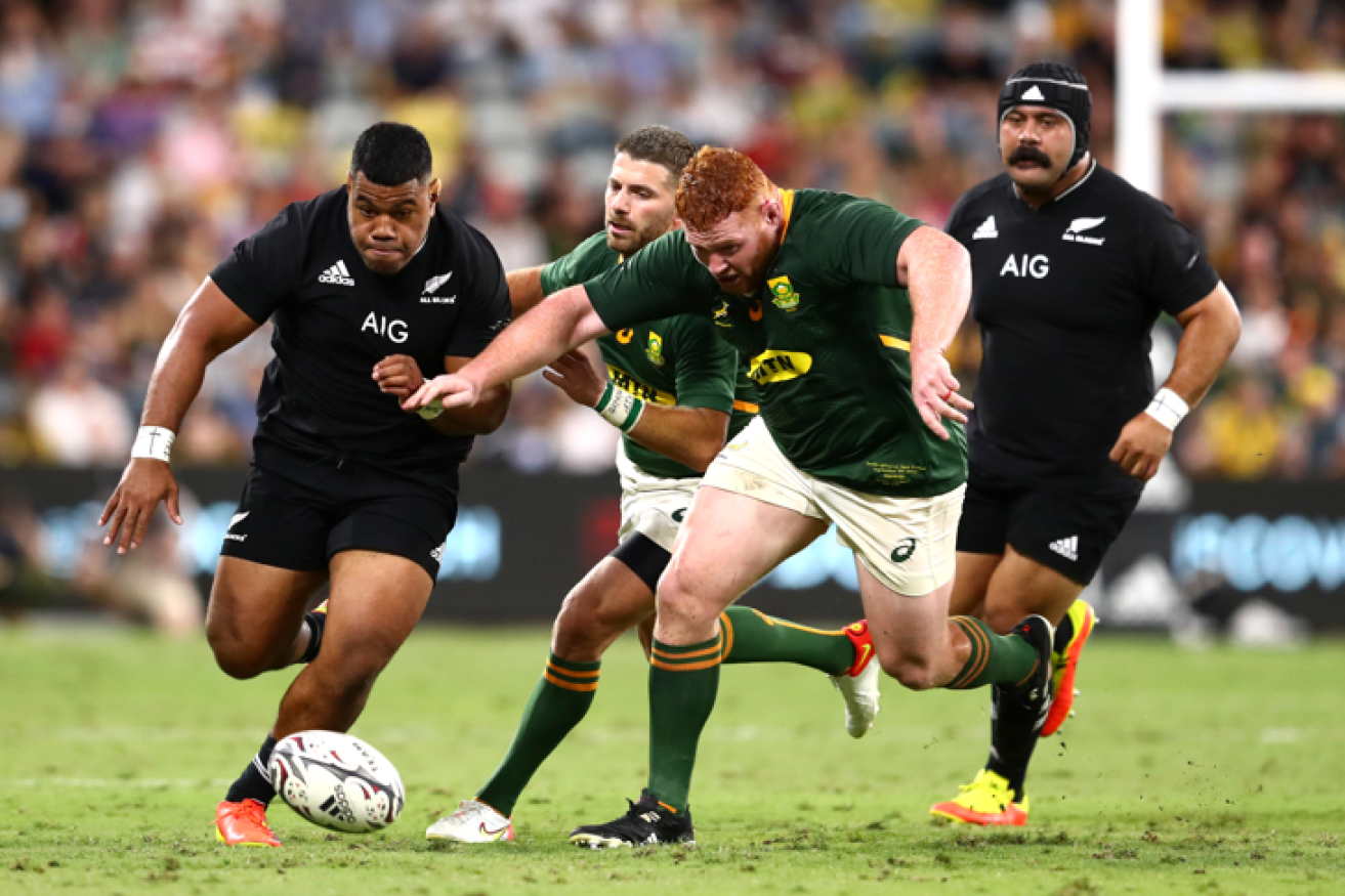 Samisoni Taukei’aho of the All Blacks thunders down the field with Springboks in hot pursuit.