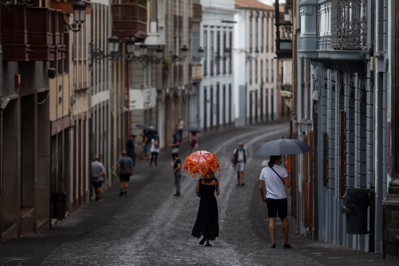 Locals walk through an ash shower in Santa Cruz de La Palma.