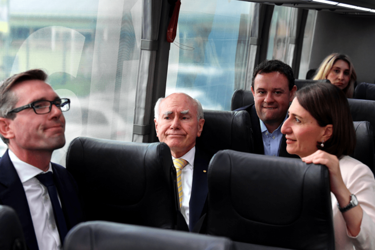John Howard, shown here in 2019 with Dominic Perrottet and soon-to-be-ex premier Gladys Berejiklian, is backing his bid to lead NSW.