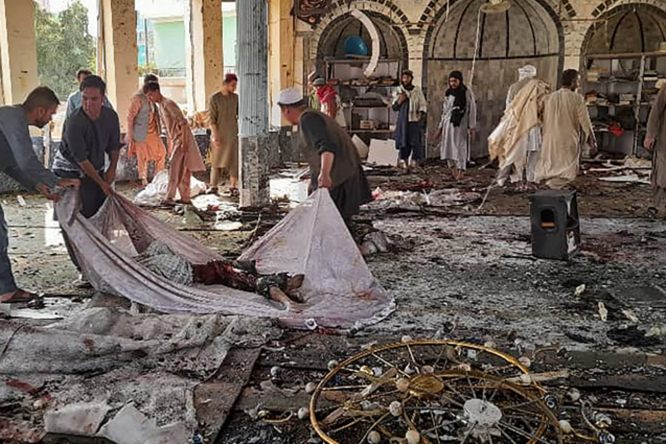 Worshippers who suirvived the horrific bodies remove bodies from the shattered Shiite mosque.