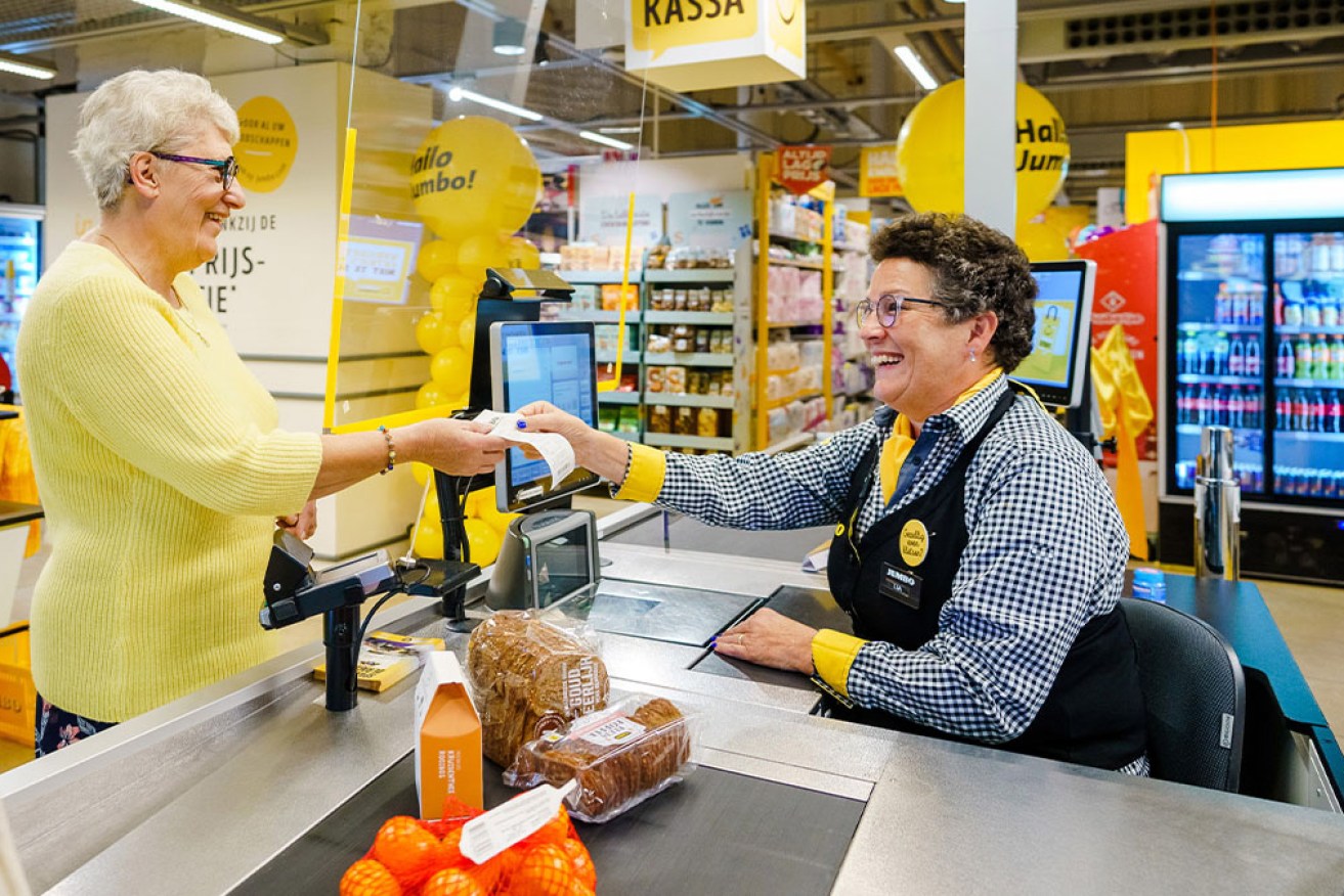 A Jumbo cashier welcomes the first customer at the Kletskassa at Udenhout. 