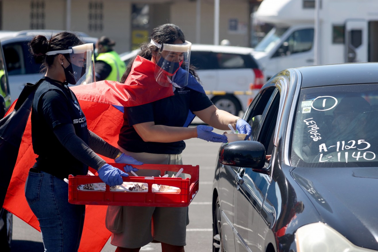 Volunteers hand out food at a mass vaccination day in Auckland. The city is 89 per cent partially vaccinated against COVID.