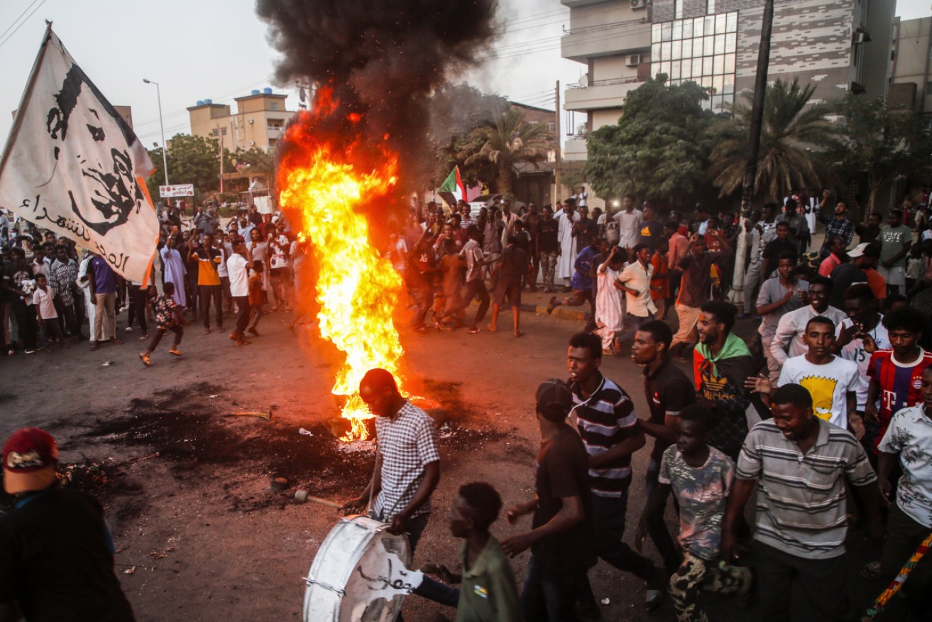 Sudanese protesters chant slogans next to burning tyres in Khartoum on Tuesday.