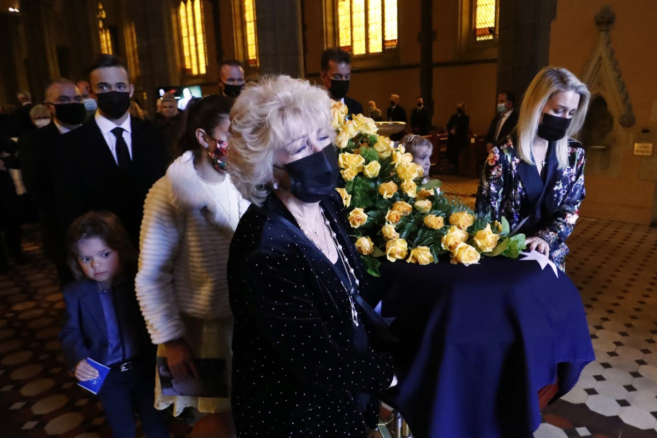 Patti Newton and daughter Lauren help to carry Bert Newton's casket out of St Patrick's Cathedral on Friday.