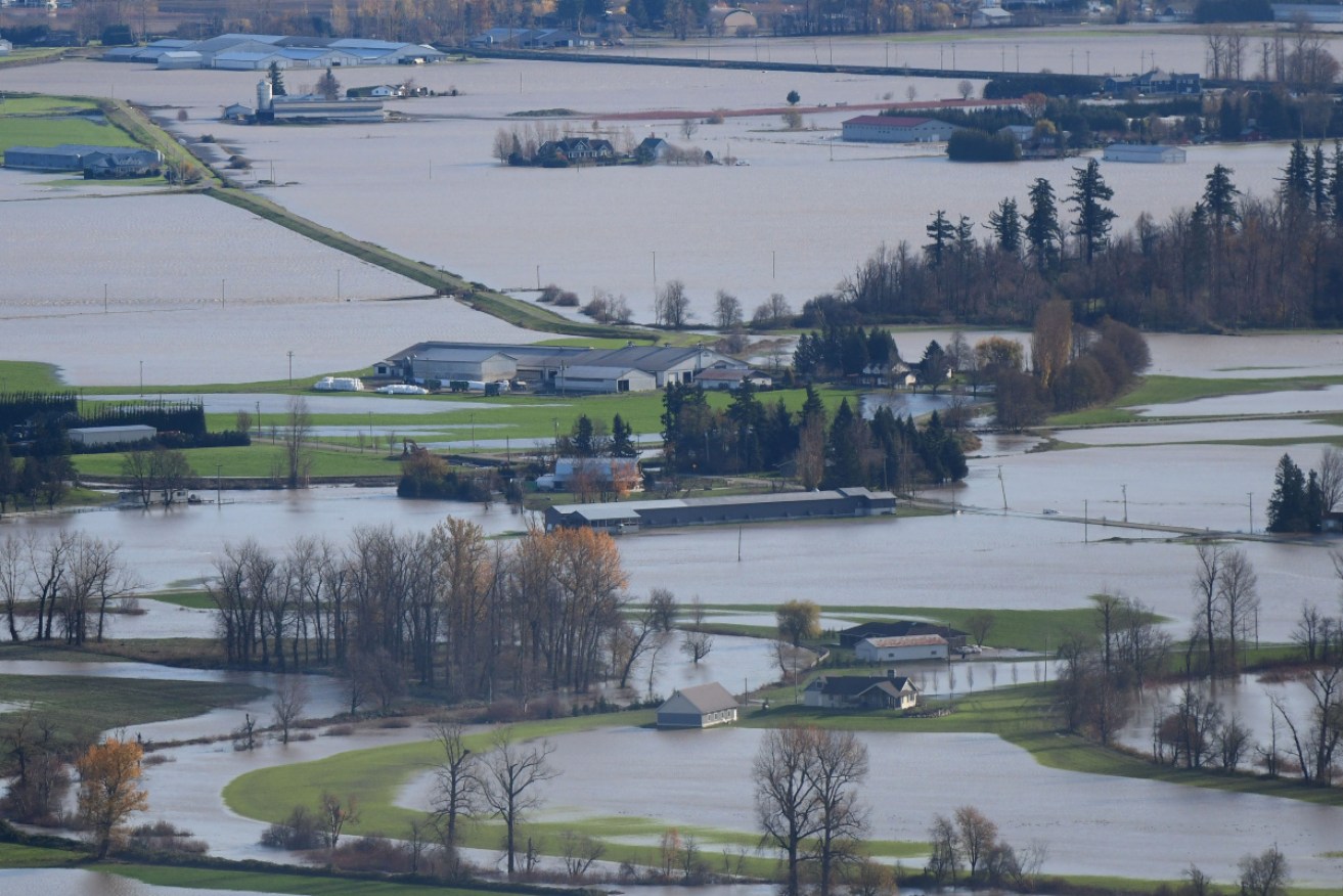 Floods in Canada's west have killed at least one person as mudslides destroyed roads and bridges.