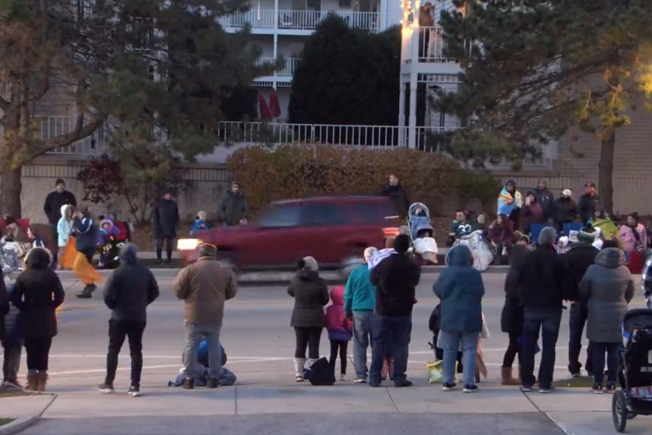 A video grab of the red four-wheel-drive driving through the parade crowd.