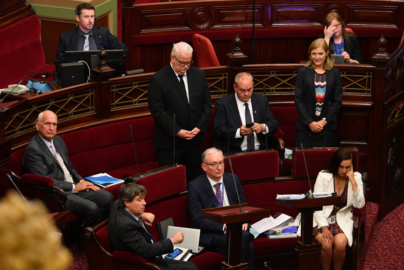 Crossbench MPs Rod Barton (centre) and Fiona Patten (right) stand to vote for Victoria's pandemic bill. 