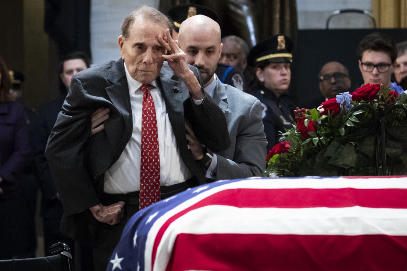 Bob Dole salutes the casket of former president George H.W. Bush in Washington in 2018.