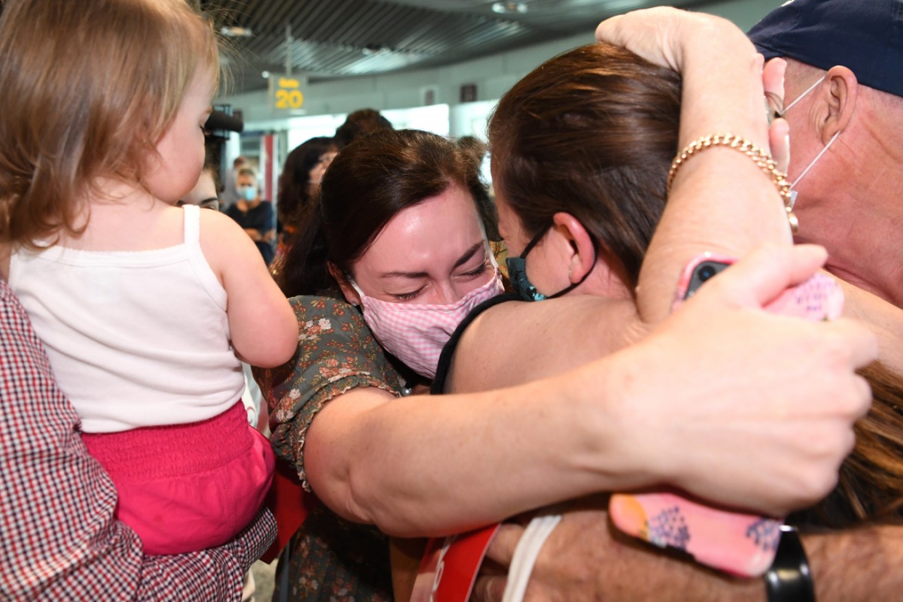 Liz Smith hugs her sister Rebecca after she arrived on the first flight from Sydney into Brisbane on Monday morning.