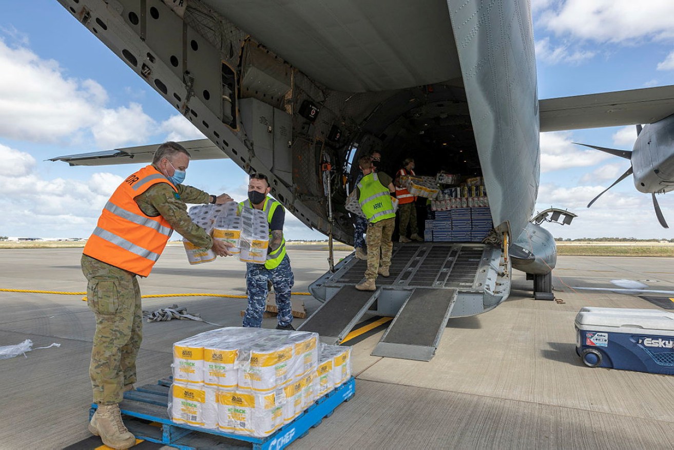 Australian Defence Force personnel load a RAAF plane to deliver critical supplies to Coober Pedy residents.