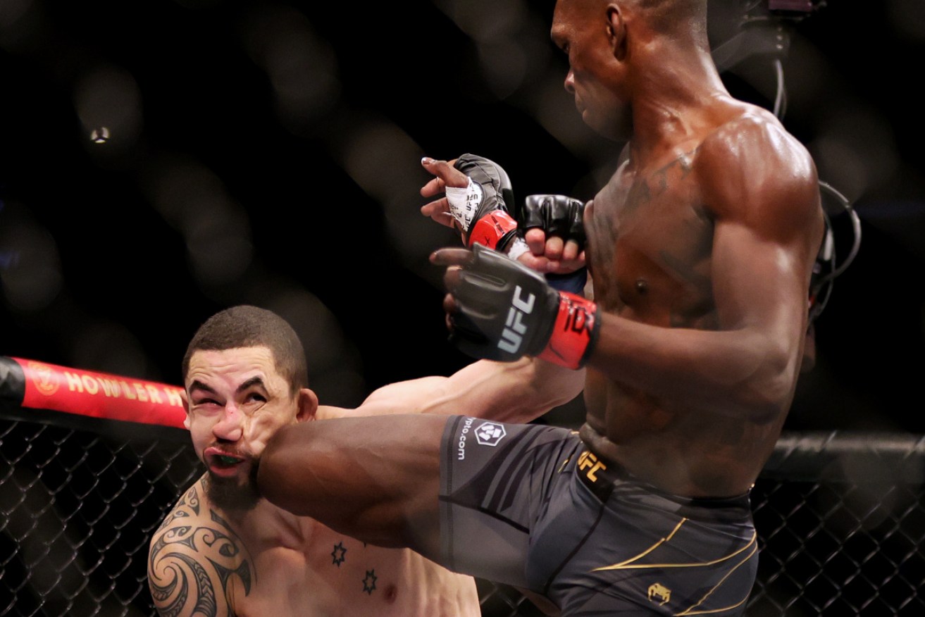 Robert Whittaker cops a knee from Israel Adesanya in Houston on Sunday.