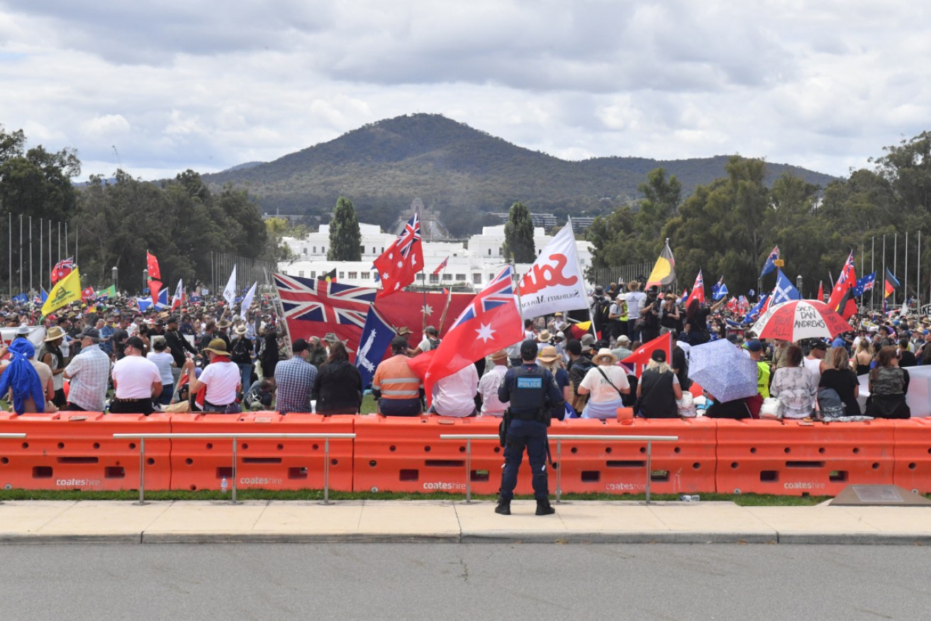 A protester at an anti-vaccination rally in Canberra had a firearm and a map of Parliament House.