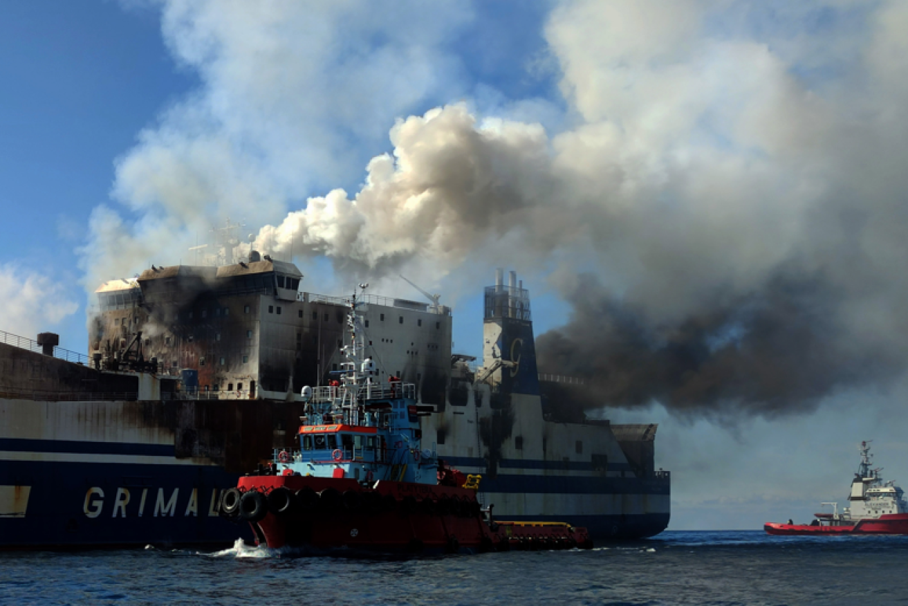 Smoke pours from the stricken vessel as a fireboat attempts to douse the two-day inferno.<i>Photo: AAP</i>