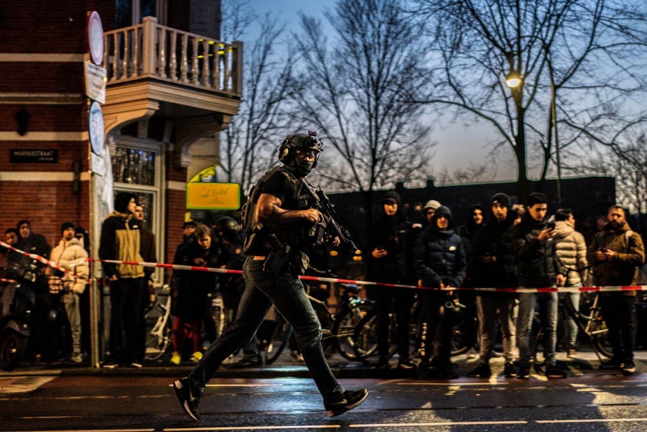 An armed Dutch police officer, outside the Apple store in Amsterdam where a man is believed to have taken hostages.