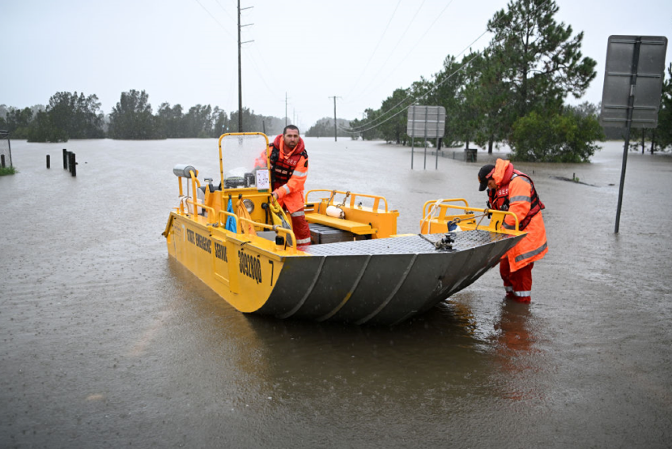 State Emergency Services volunteers slide their evacuation boat into the flooded streets of Logan, south of Brisbane.Photo: Getty