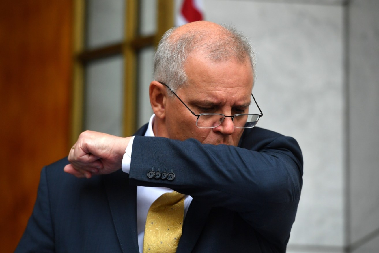 Scott Morrison coughs during Tuesday's media briefing with Peter Dutton.