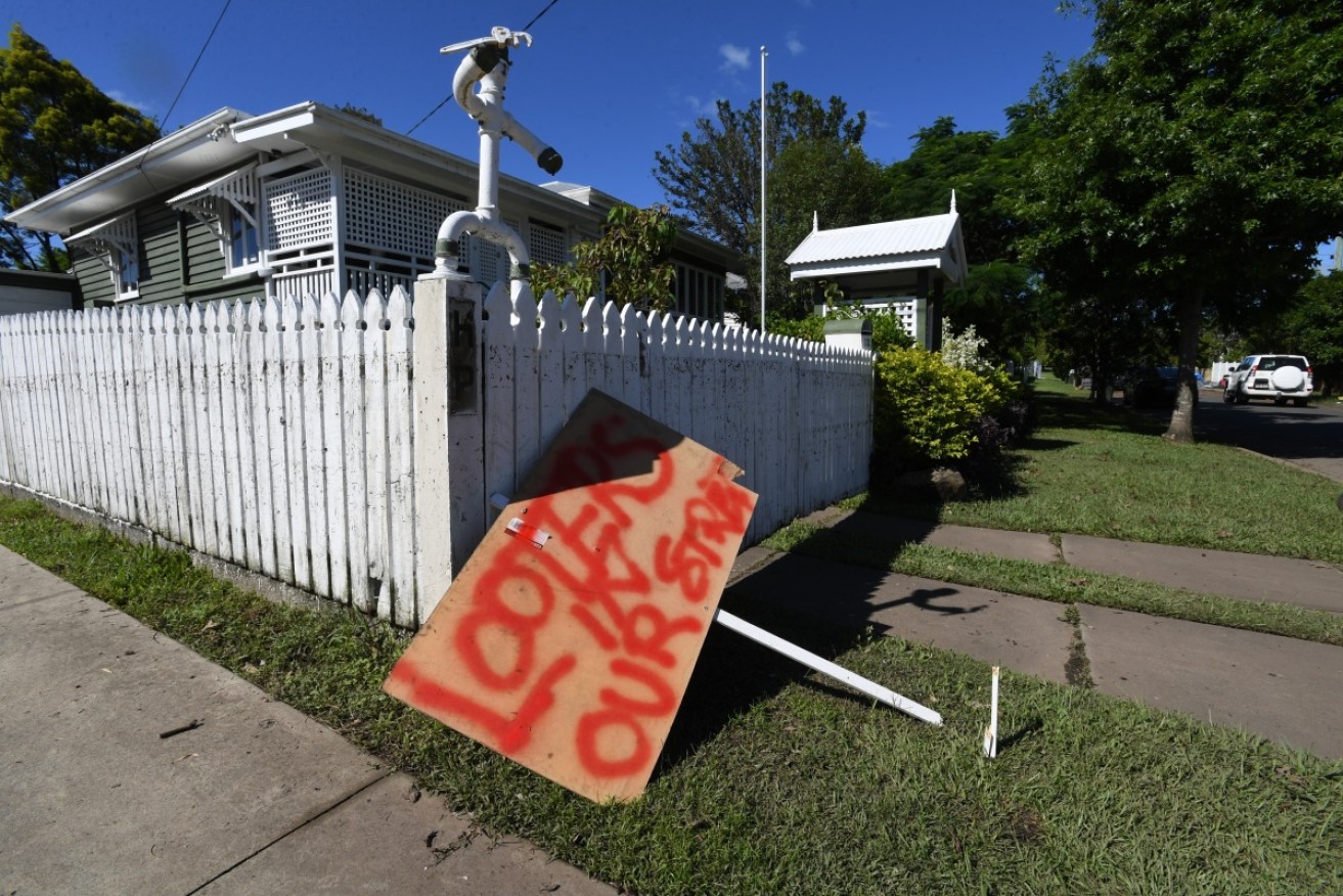 A sign, outside a flood-affected property in Brisbane, warns of looters.