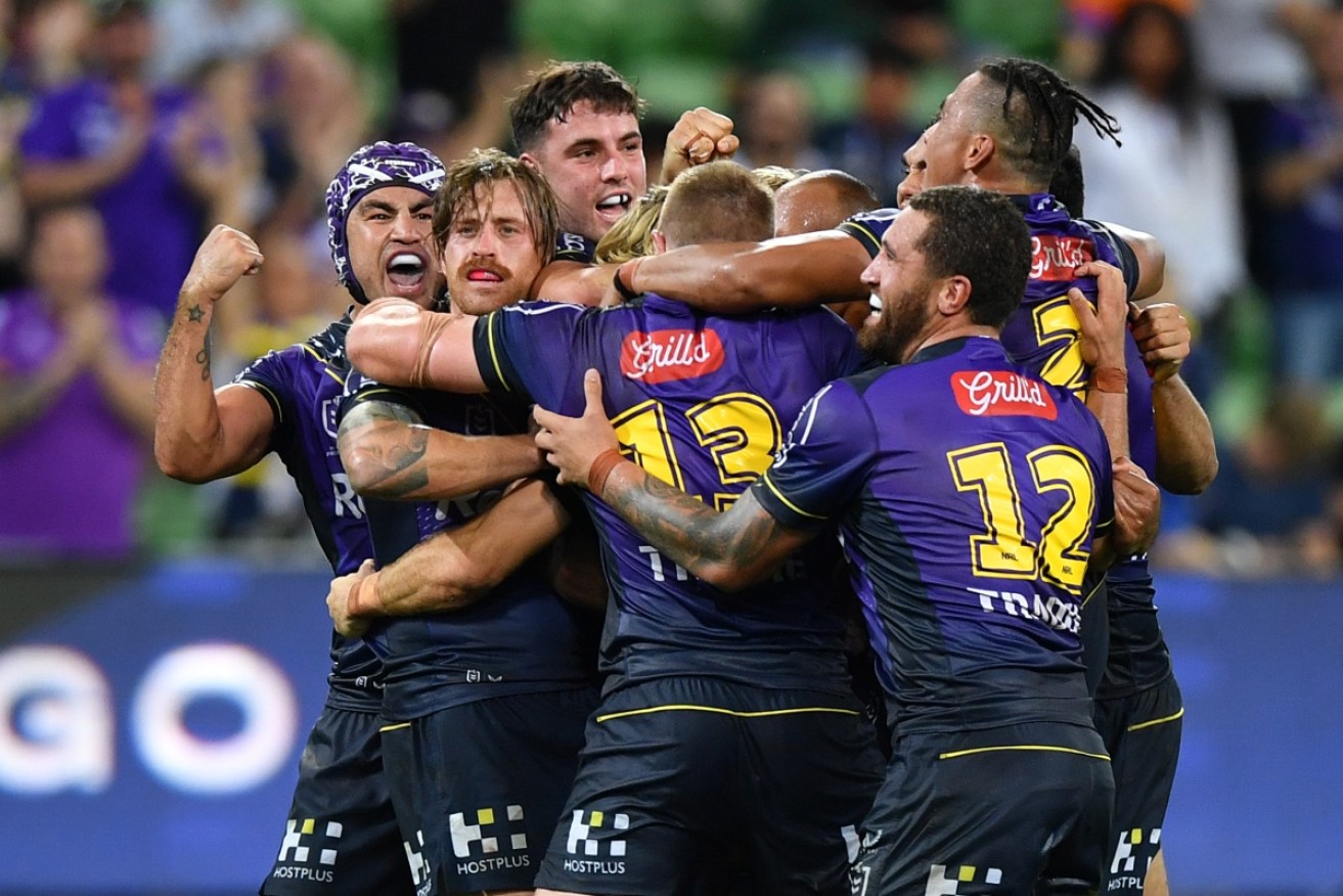 Teammates mob Ryan Papenhuyzen after his field goal in Melbourne's 15-14 win over Souths on Thursday night.