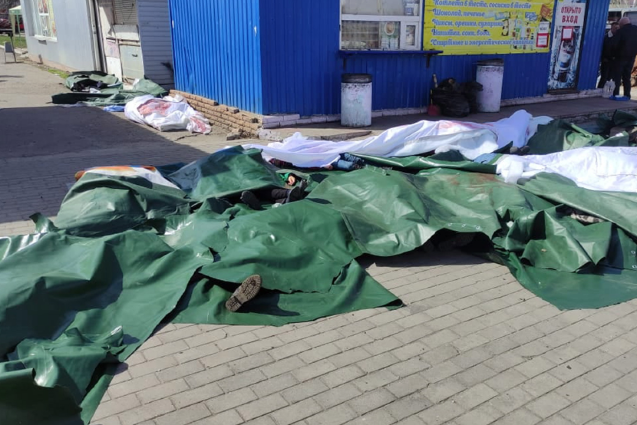 Beneath the tarpaulins bodies remain where they were cut down at Kramatorsk station.<i>Photo: EPA</i>
