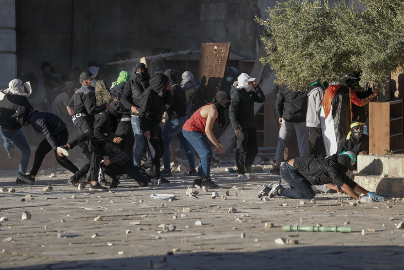 Palestinians gather rocks during the fighting in and around the al-Aqsa mosque.<i>Photo: AP</i>