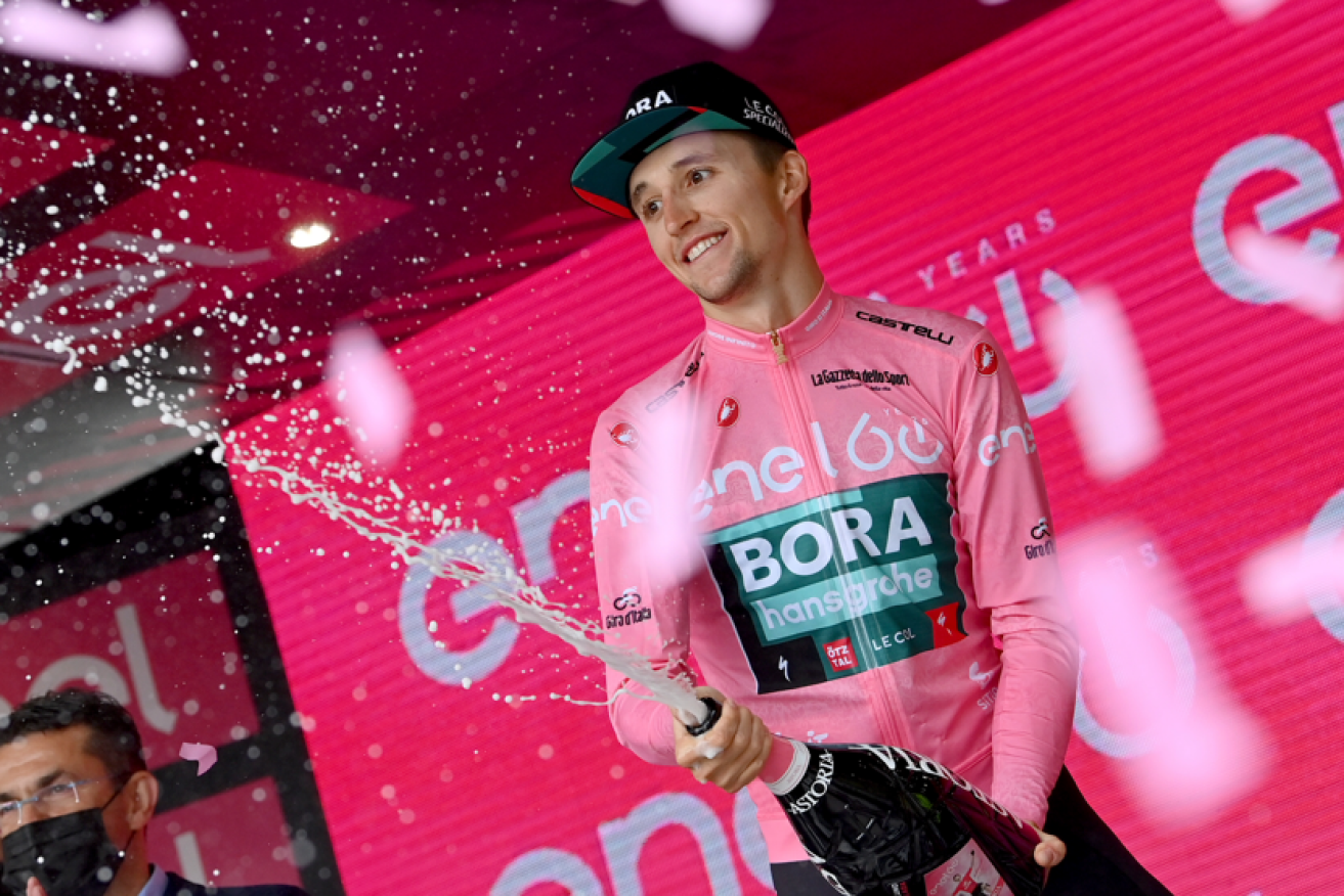 In the pink: Jai Hindley serves champagne to go with his leader's maglia rosa jersey.