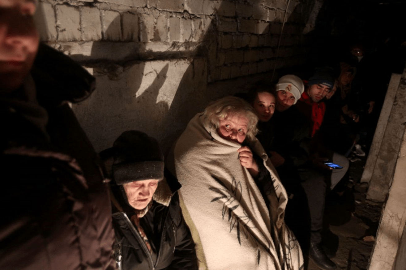 An old woman shivers beneath her blanket with other refugees from the Russian blitz pulverising their Sievierodonetsk home. <i>Photo: Getty</i>