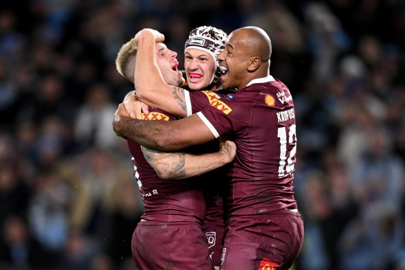 Queensland players Cameron Munster, Kalyn Ponga and Felise Kaufusi celebrate the Maroons victory over NSW.