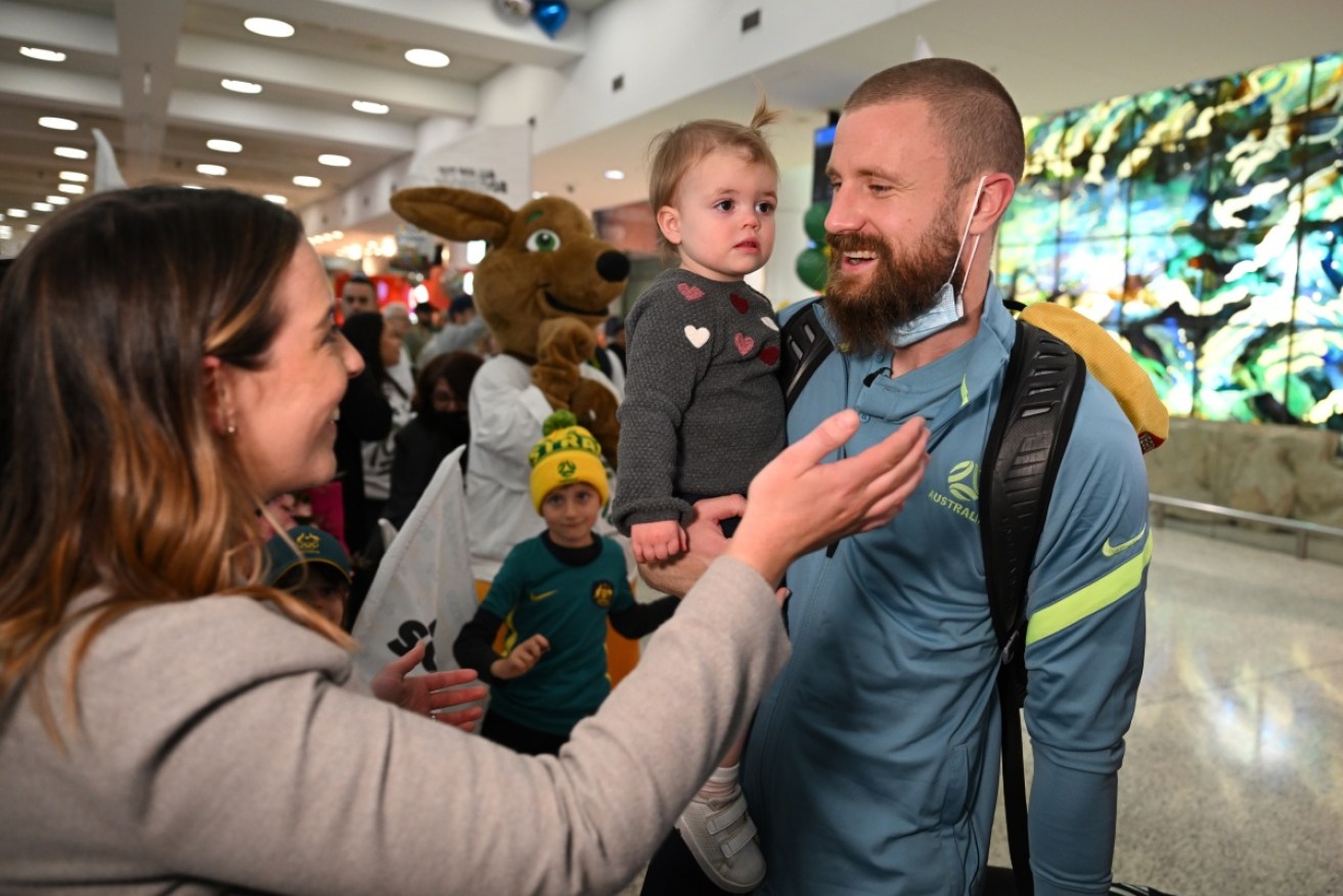 Socceroos goalkeeping hero Andrew Redmayne was welcomed home by wife Caitlin and daughter Poppy.