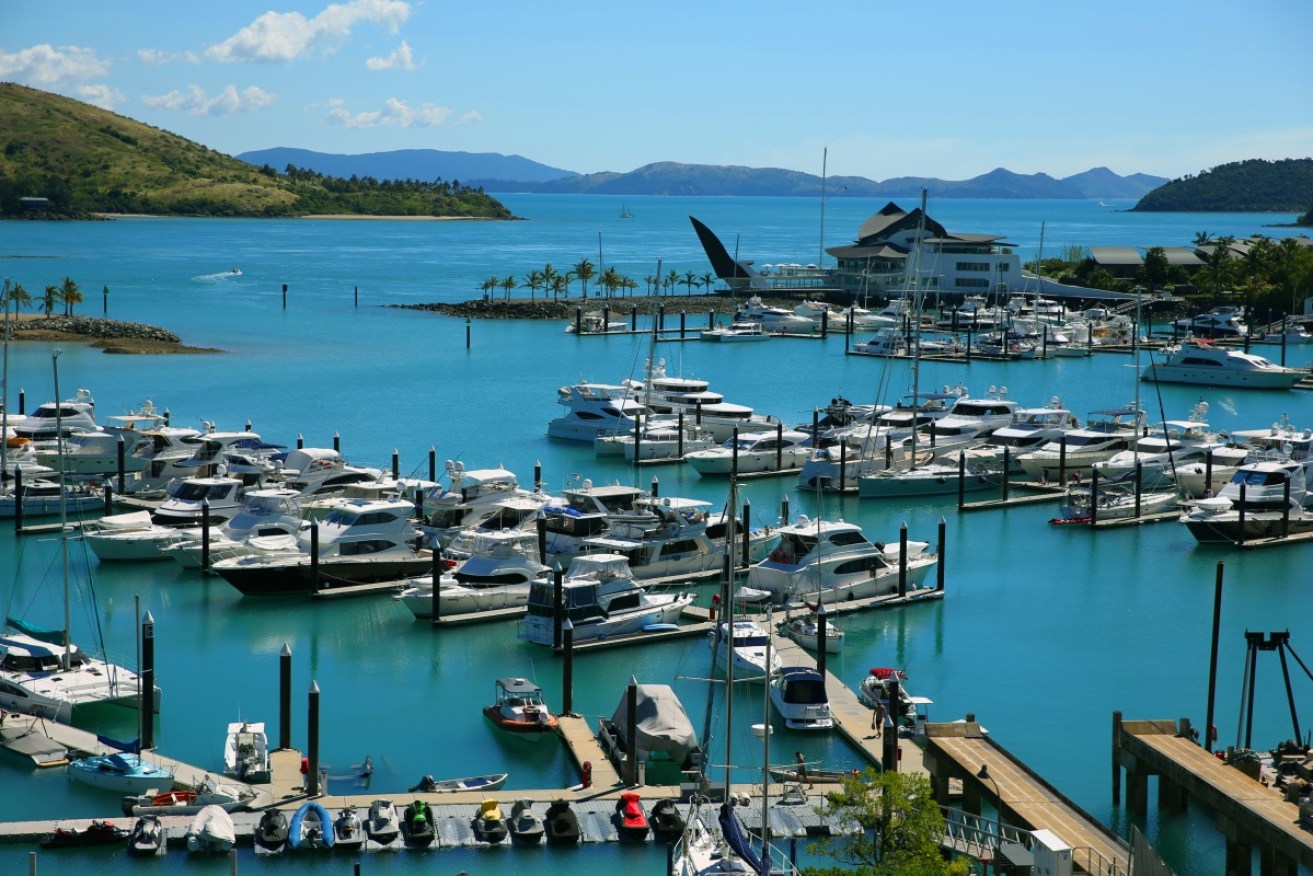 A woman has died after a golf buggy rolled on Hamilton Island.