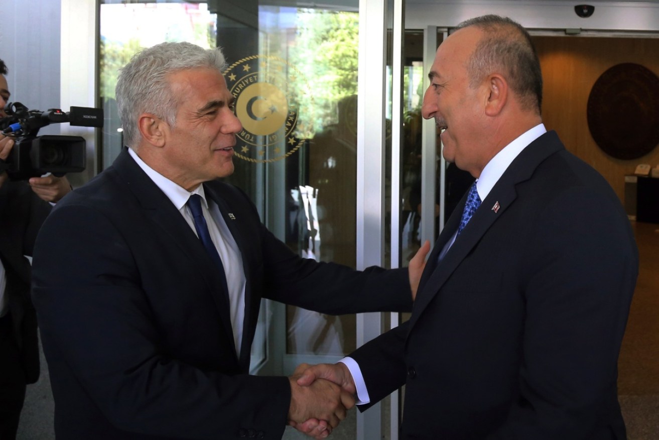 Israeli Foreign Minister Yair Lapid greets Turkish counterpart Mevlut Cavusoglu.
