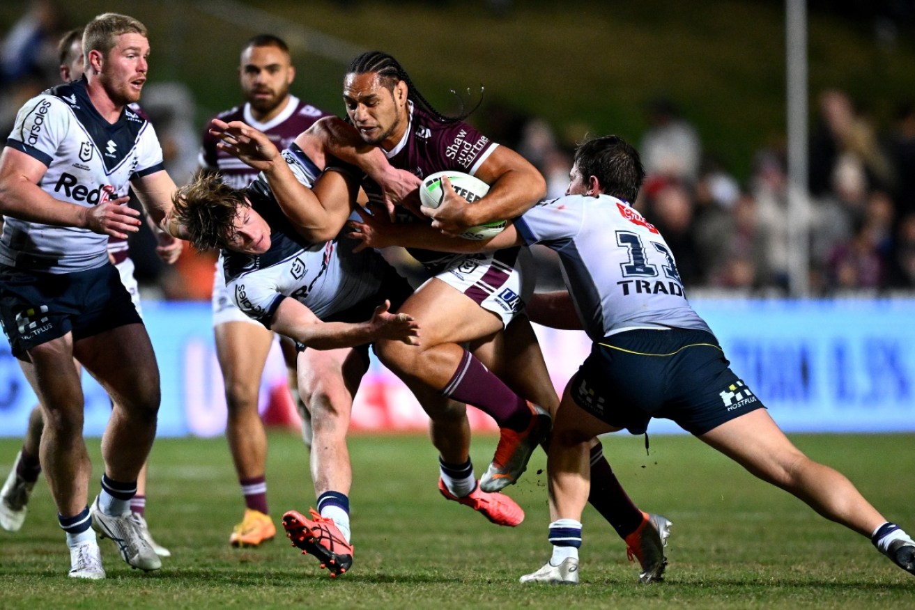 Martin Taupau of the Sea Eagles is tackled by Melbourne's Harry Grant (left) and Chris Lewis.  