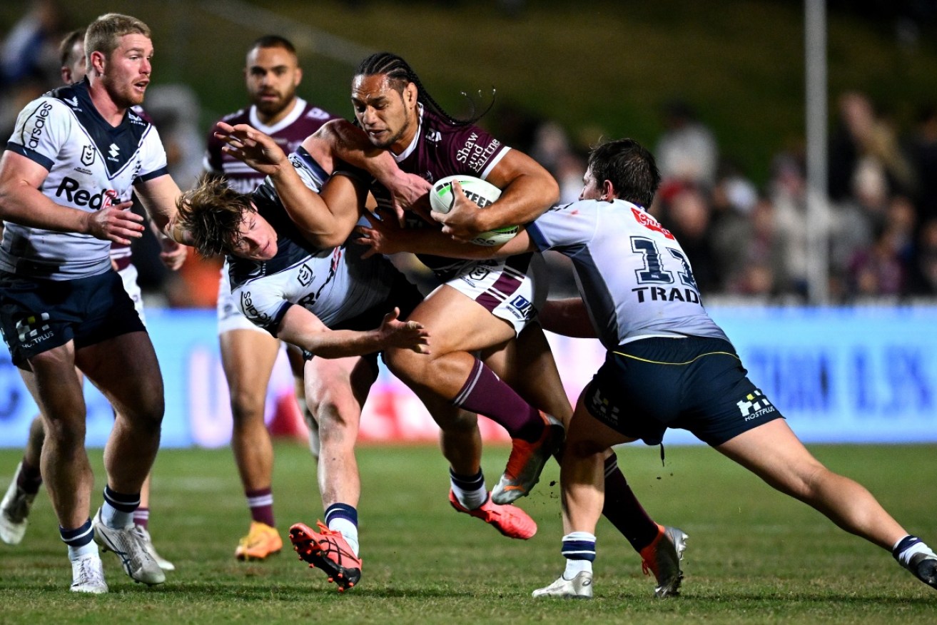 Martin Taupau of the Sea Eagles is tackled by Melbourne's Harry Grant (left) and Chris Lewis.