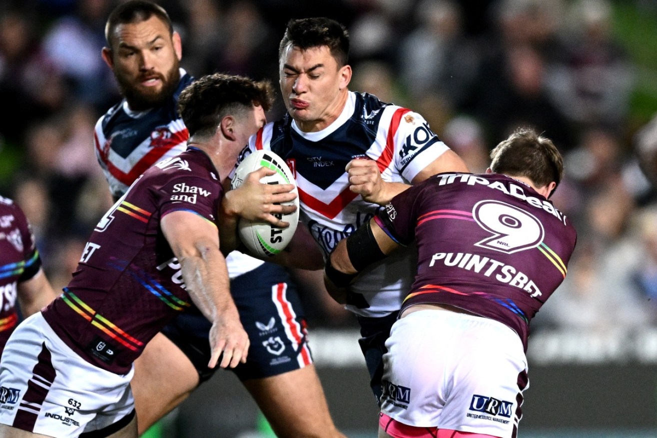 Roosters star Joey Manu takes on Manly's defence on Thursday night.
