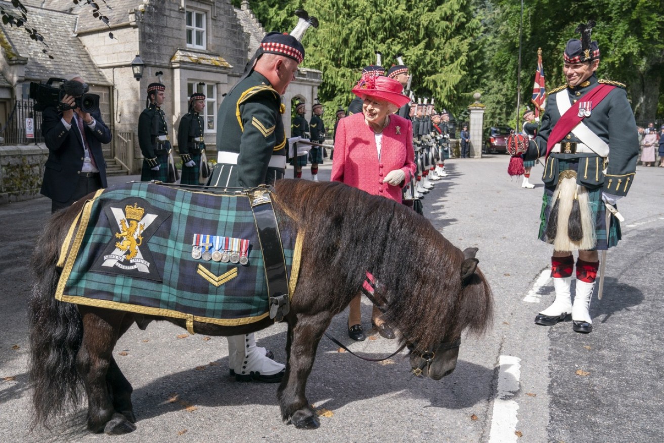 A smiling Queen greets soldiers and a Shetland pony mascot at the Balmoral Castle gates in 2021.