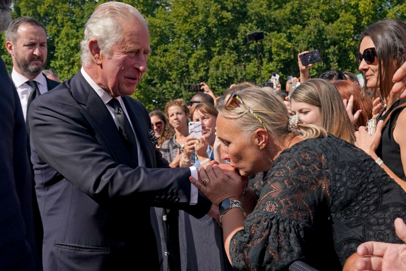 King Charles greets mourners outside Buckingham Palace, including this subject who planted a kiss on the royal hand. <i>Photo: AP</i>
