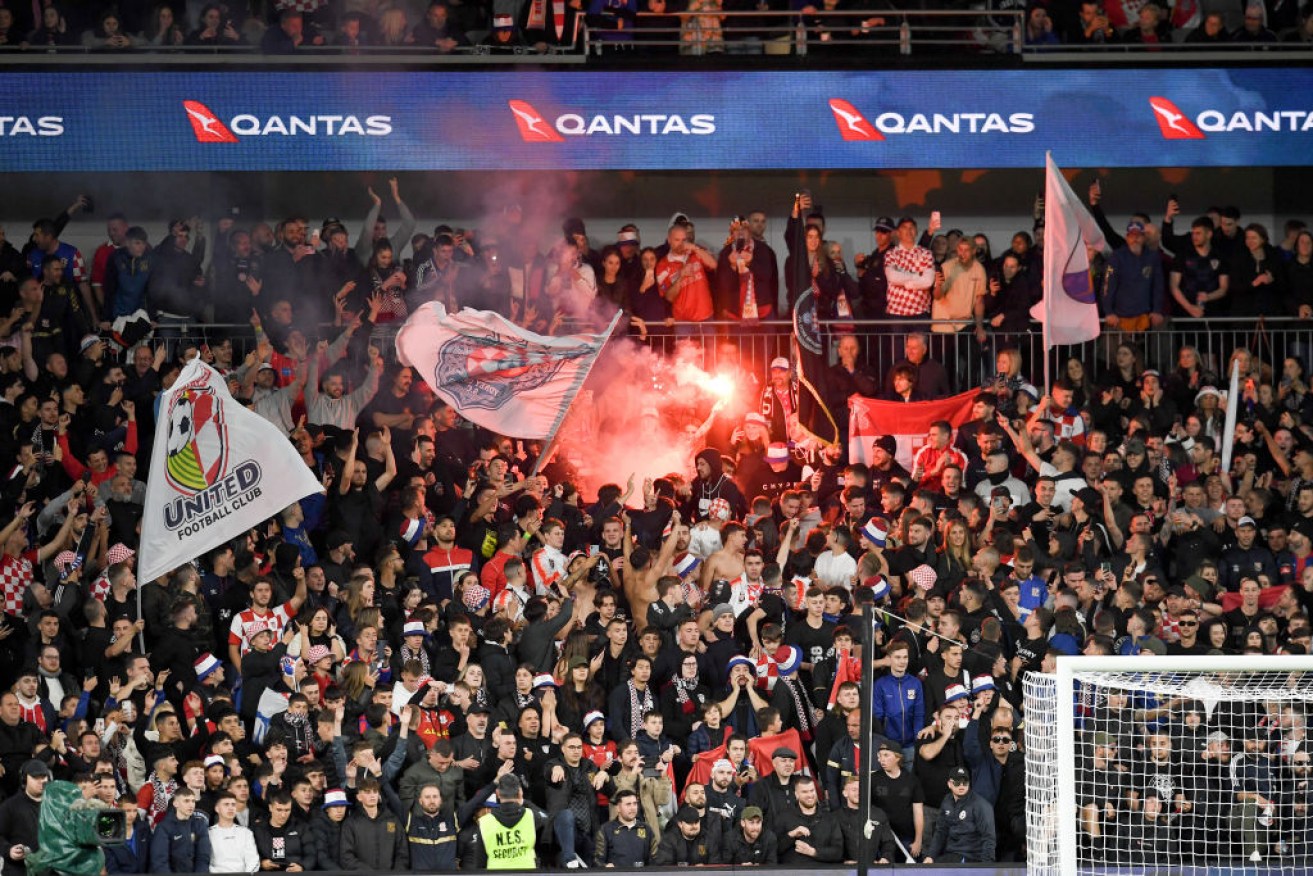 Sydney United fans light a flare during the Australia Cup Final football match between Sydney United FC and Macarthur FC.