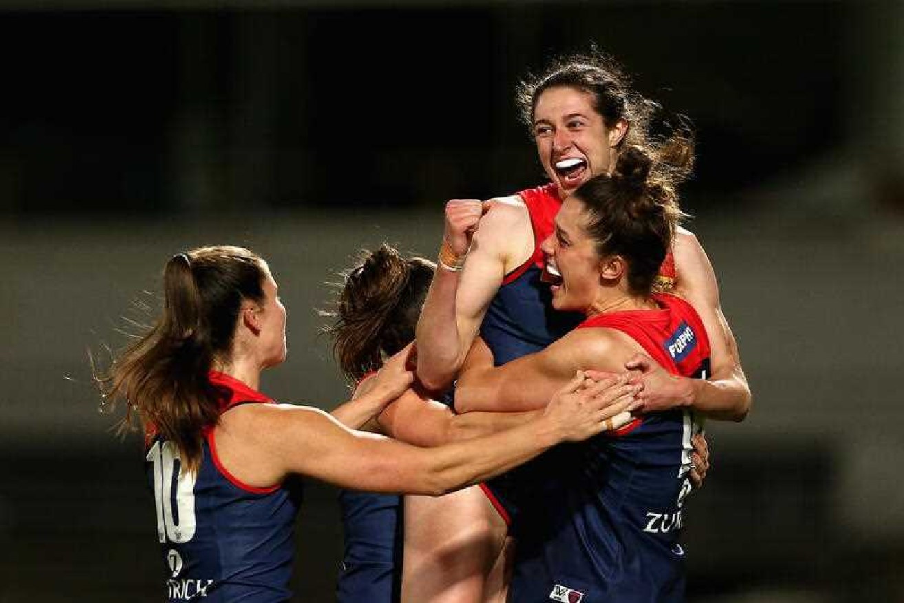 Melbourne players surround Alyssa Bannan to celebrate her  goal during their 21-point AFLW qualifying final win over Adelaide.