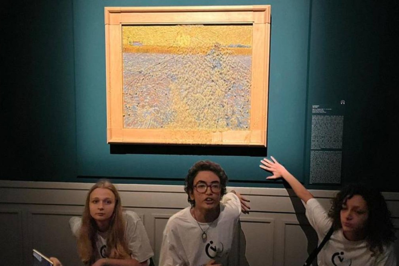 Climate activists stick their hands to the wall beneath Vincent Van Gogh's 'The Sower'