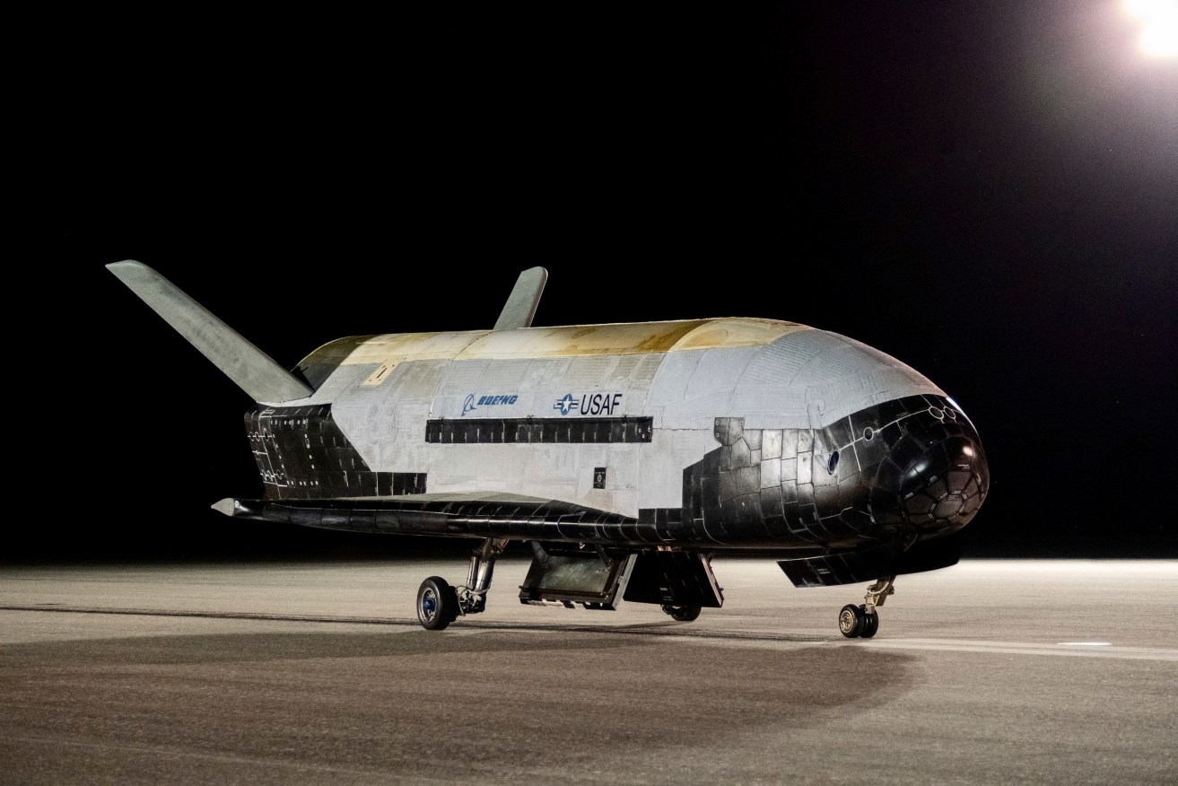 An unmanned US military space plane, which looks like a miniature space shuttle, has landed in Florida after spending a record 908 days in orbit.