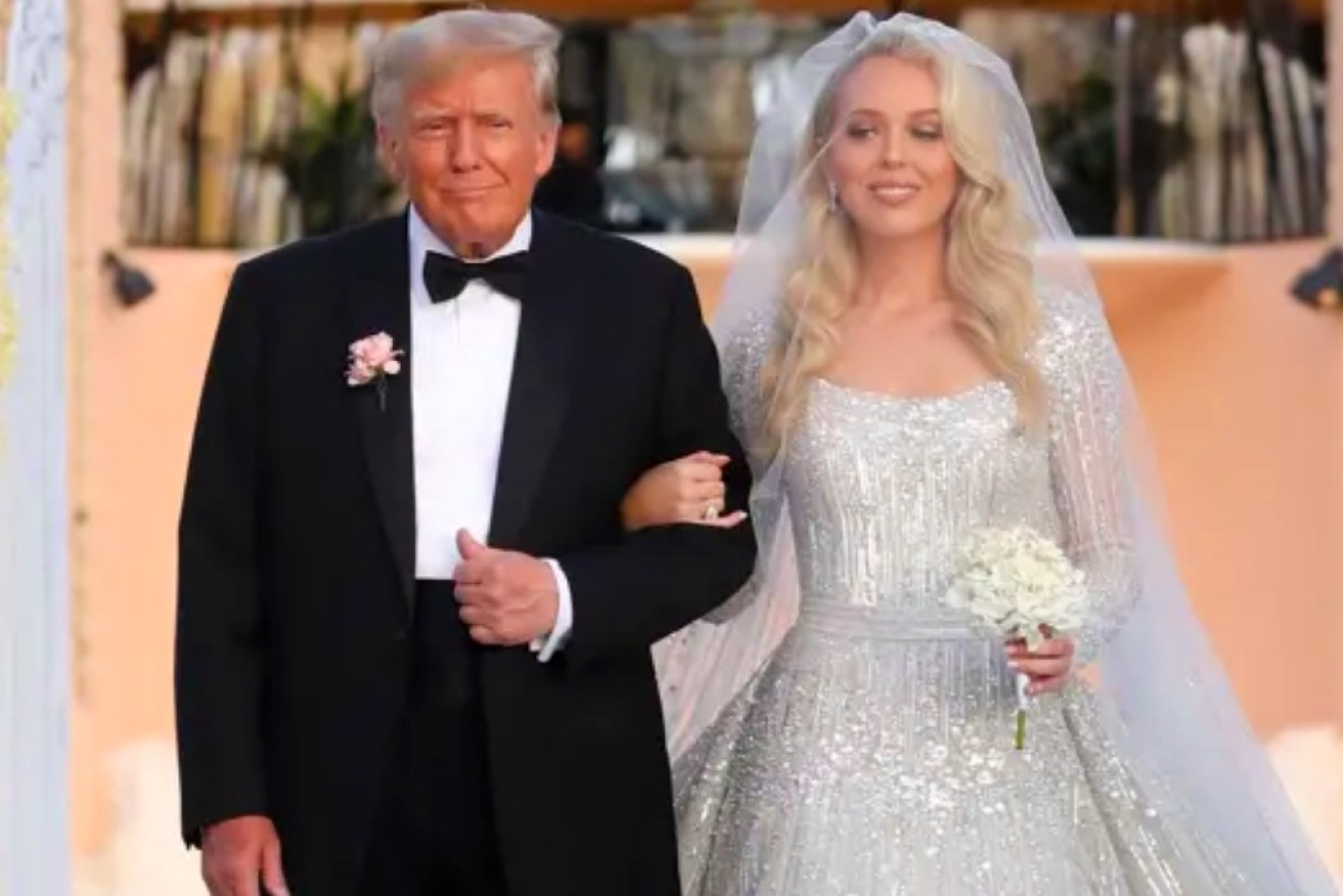 Former US President Donald Trump walks his youngest daughter Tiffany down the aisle.