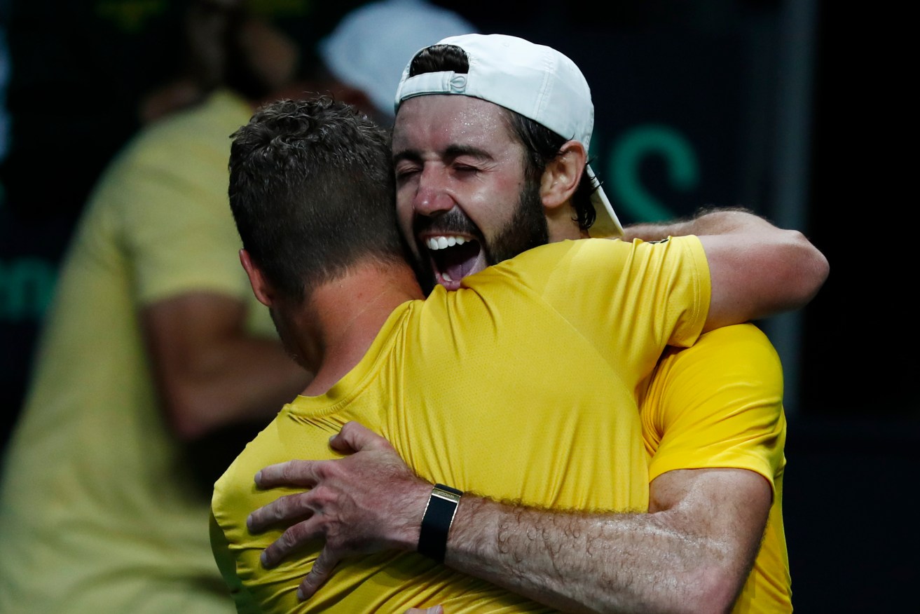 Jordan Thompson celebrates with Aussie captain Lleyton Hewitt after his Davis Cup quarter-final win.