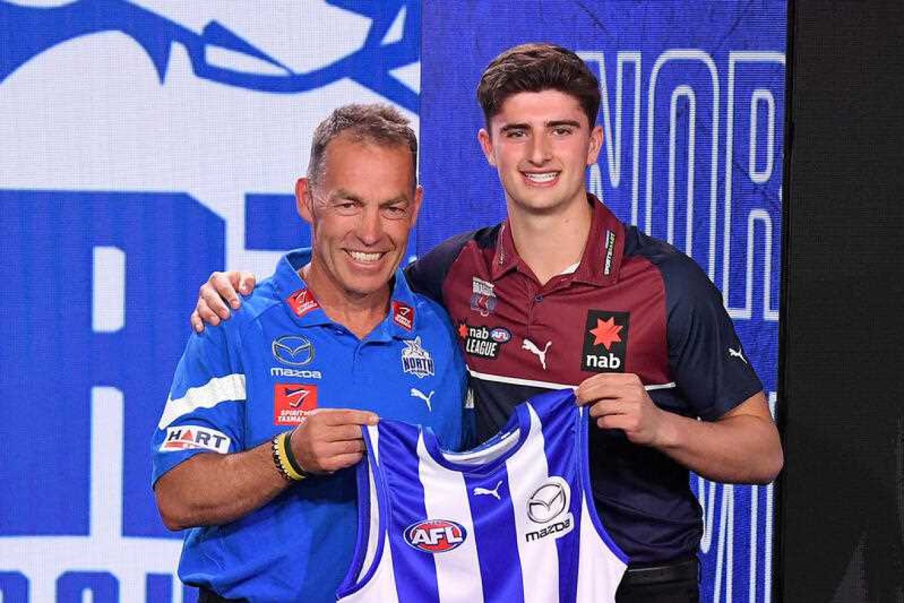 The AFL is investigating anti-Semitic online abuse of No.3 draft pick Harry Sheezel, pictured with North Melbourne coach Alastair Clarkson.