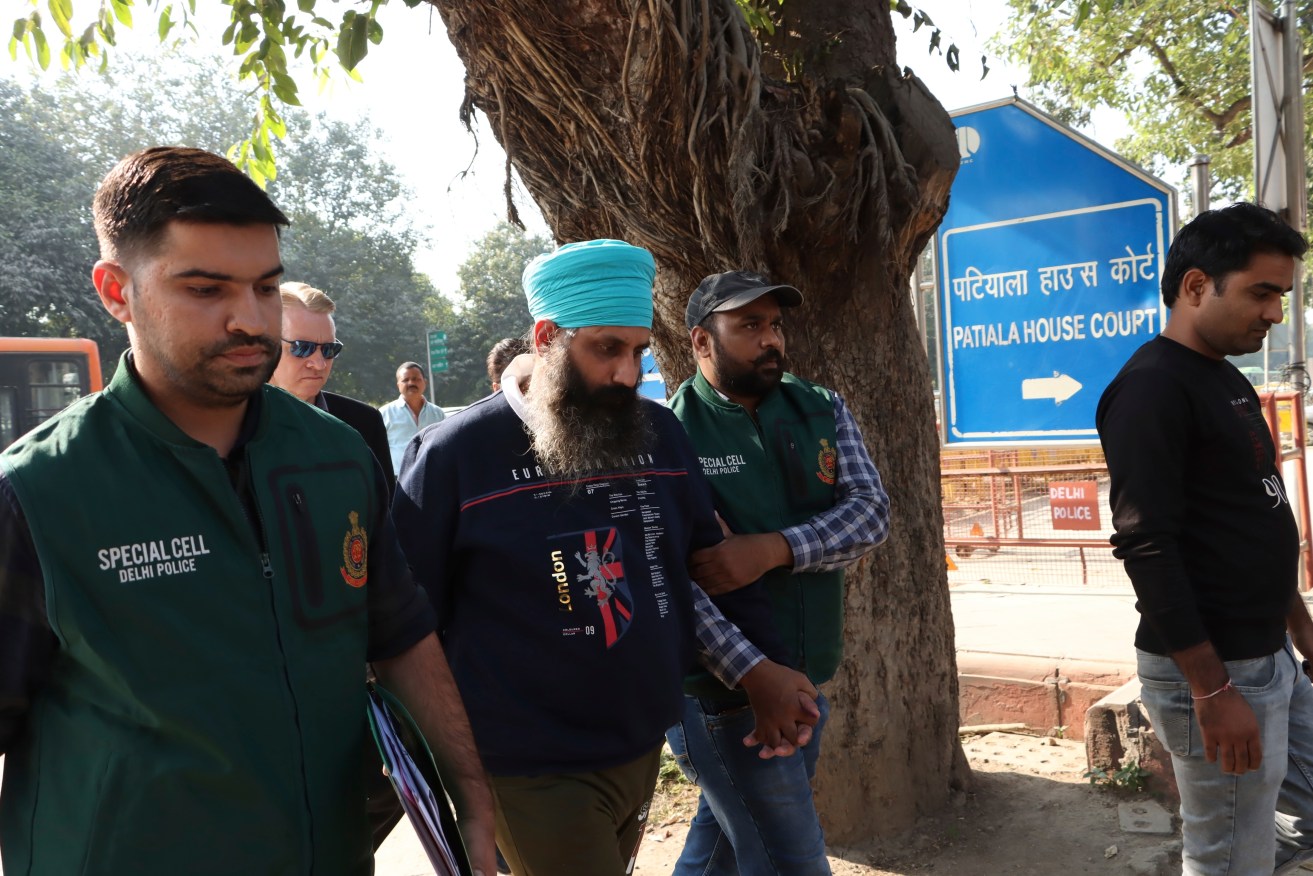 Policemen escort Rajwinder Singh, 38, after he was arrested in New Delhi.